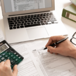 Persona organizando sus finanzas con una calculadora y documentos, preparando un plan para implementar el Método Avalancha y reducir deudas.