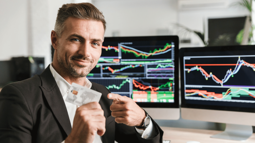 Persona sosteniendo una tarjeta de crédito frente a gráficos financieros que ilustran el desempeño de la bolsa argentina, con tendencias de acciones y datos económicos.