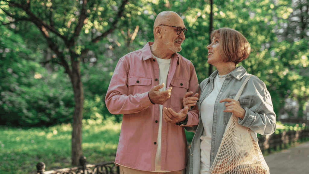 Pareja de adultos mayores caminando por un parque, disfrutando de su tiempo juntos mientras reflexionan sobre la jubilación mínima en Argentina y la importancia de la planificación financiera.